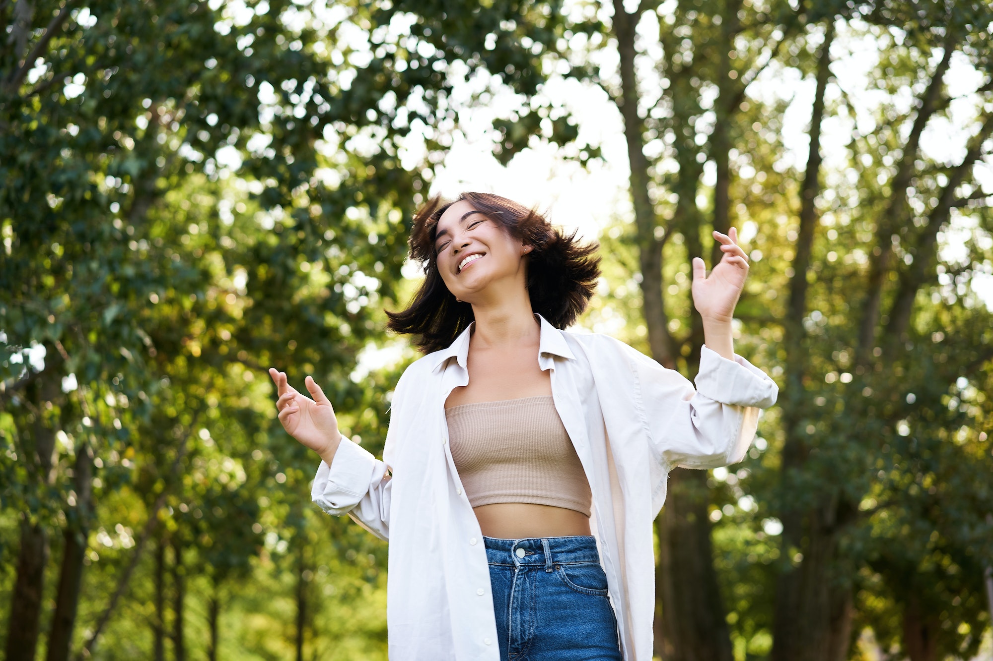 Happy people. Carefree asian girl dancing and enjoying the walk in park, feeling happiness and joy